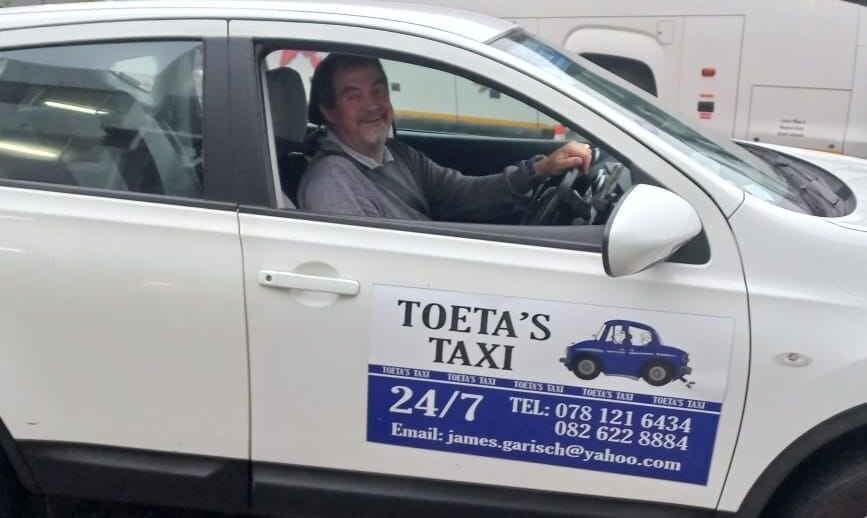 Taxi services driver in a white vehicle.